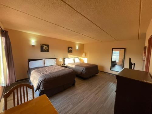 圣厄斯塔什Motel St-Eustache的酒店客房设有两张床和一张桌子。