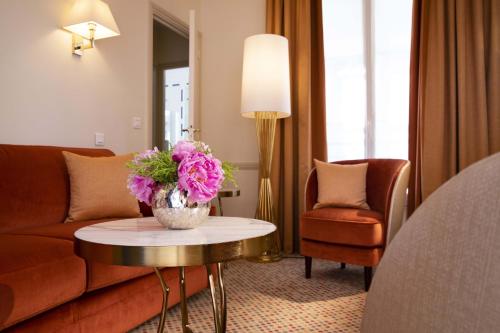 巴黎瑞典圣日耳曼酒店的客厅配有沙发和鲜花桌
