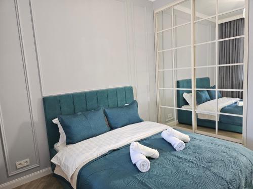 阿拉木图3 room Gagarin Park Residential Complex near MEGA Shopping Mall的一间卧室配有蓝色的床和2条毛巾