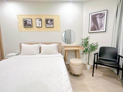 头顿The Sóng Hotel & Apartment Vũng Tàu - VTLand的一间卧室配有一张床、一张桌子和一把椅子