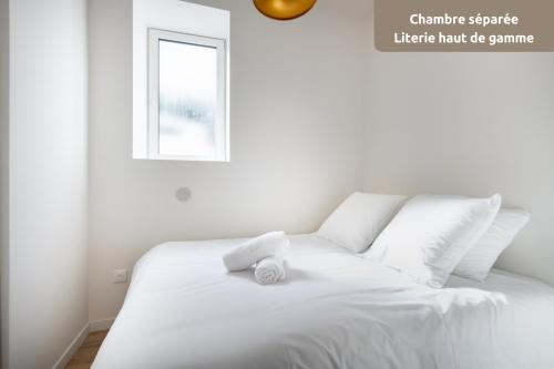 La DestrousseROMARIN * Lumineux * Linge hôtelier * Fibre * Confort的白色的床,上面有一条白色毛巾