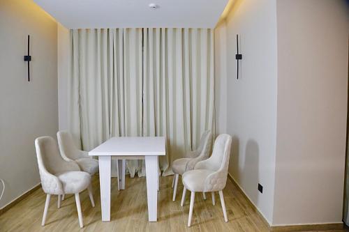 开罗Golden House的白色的用餐室配有白色的桌椅