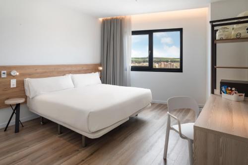 埃希哈B&B HOTEL Écija的卧室设有一张白色大床和一扇窗户。