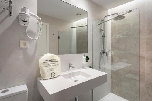 埃希哈B&B HOTEL Écija的白色的浴室设有水槽和淋浴。