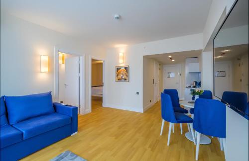 巴统PANORAMA Orbi Beach Resort Center Suite的客厅配有蓝色的椅子和桌子