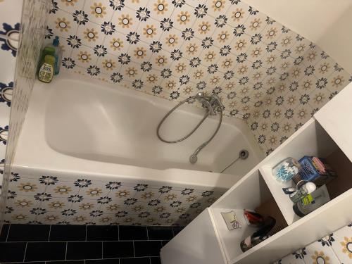 布鲁塞尔Résidence Europe的浴室设有白色浴缸,装饰有花卉壁纸
