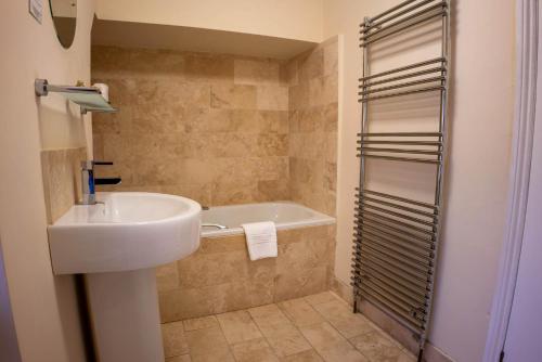 斯卡伯勒East Ayton Lodge Hotel, Scarborough的浴室配有盥洗盆和浴缸。