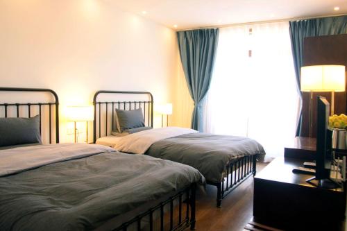 丽江La Maison du Laoshay Lijiang的一间卧室设有两张床和窗户。