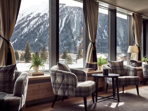 达沃斯Precise Tale Seehof Davos的客房设有带椅子和桌子的大窗户。