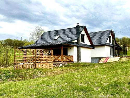 GrywałdPrzystanek Przylasek的黑色屋顶的大型白色房屋