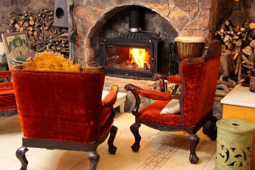 丽江La Maison du Laoshay Lijiang的客厅配有两把椅子和壁炉