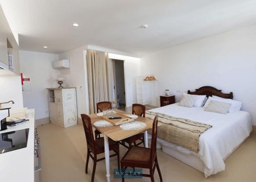 佩纳菲耶尔MyStay - Casa Matriz Séc XVI的卧室配有一张床和一张桌子及椅子