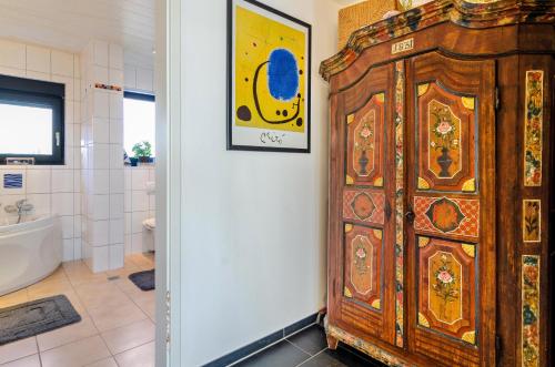 MarkelfingenStella Lilia的带浴缸的浴室内的大型木制橱柜