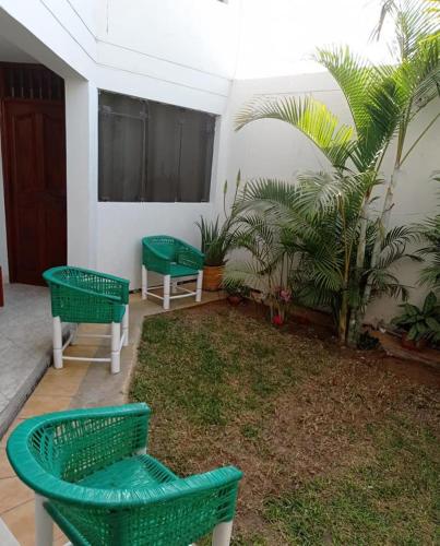 皮斯科Posada de Mary的庭院里设有3把绿色椅子和1株植物