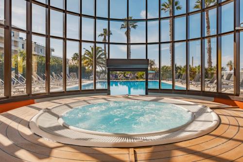 马赛金色郁金香马西利亚别墅酒店的带大窗户的客房内的热水浴池