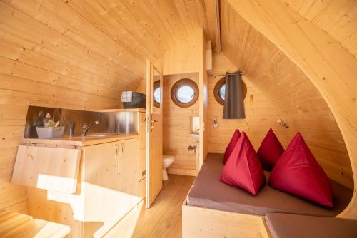 因特拉肯Camping Lazy Rancho - Eiger - Mönch - Jungfrau - Interlaken的一个小房子,长凳上摆着红色枕头