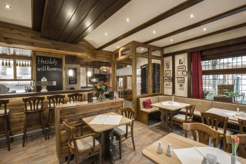 比特堡路易米勒酒店的一间带桌椅的餐厅和一间酒吧