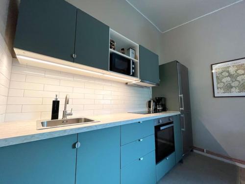 斯德哥尔摩Elegant house, Stockholm的厨房配有蓝色橱柜和水槽