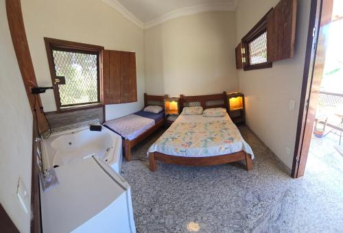 CaratingaFazenda do Prata Ecoresort的一间带两张床和浴缸的卧室