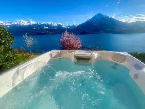 锡格里斯维尔CHALET EGGLEN "Typical Swiss House, Best Views, Private Jacuzzi"的享有湖泊和山脉美景的热水浴池