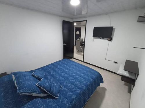 波哥大Departamento amoblado en Kennedy central的一间卧室配有蓝色的床和镜子