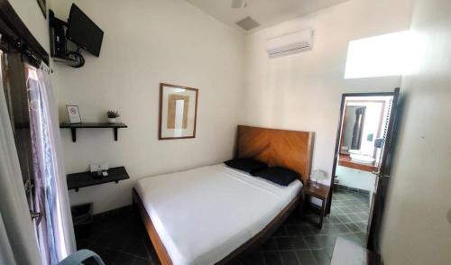 莱昂Hotel and Coffe Azul的一间小卧室,配有一张床和镜子