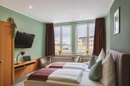 比特堡路易米勒酒店的酒店客房设有两张床和电视。