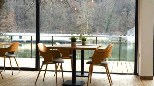 奥格尼亚诺沃Waterside SPA Hotel的配有大窗户的客房内的桌椅