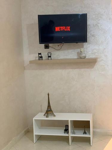丹吉尔cozy appartement meublé的墙上的电视白色桌子