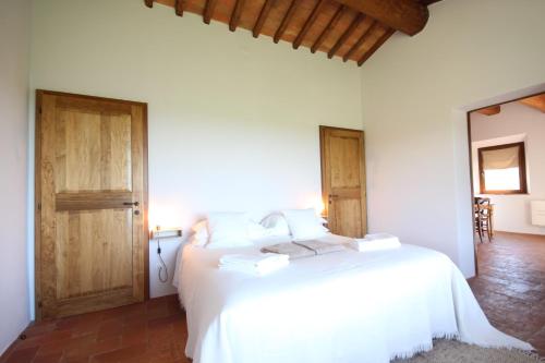 CampagnaticoMarrucheti 82的卧室配有白色的床和2扇木门