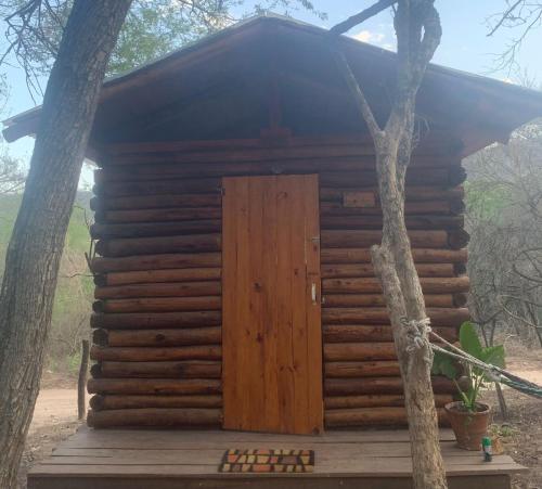 Coronel MoldesEl Paraíso Ecolodge的两棵树中间的木舱,有一扇门
