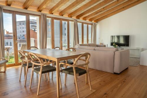拉科鲁尼亚La Gallega by Upper Luxury Housing的客厅配有桌椅和沙发