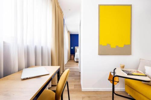 Giv‘atayimSirkin 16 Hotel - Autonomous hotel的一间带桌子和黄色沙发的用餐室