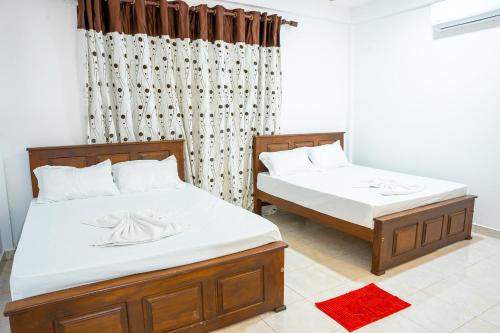 DematapelessaUdawalawe Elegant Hostel的卧室内两张并排的床