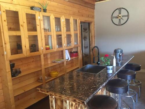 埃斯卡兰特Ponderosa Inn的厨房配有带水槽和凳子的柜台。