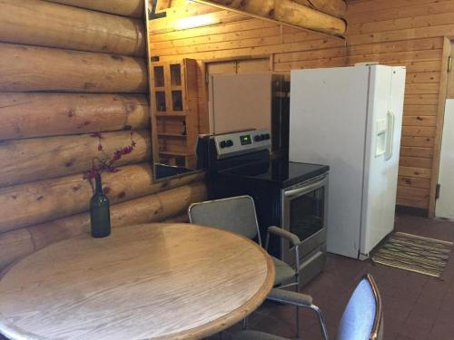 埃斯卡兰特Ponderosa Inn的厨房配有桌子、冰箱和桌椅