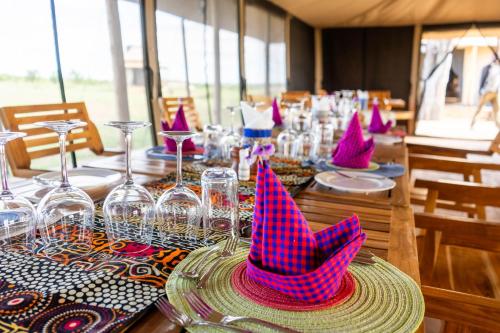 塞伦盖蒂国家公园Serengeti Malaika Luxury Camp的一张桌子上面有粉红色的派对帽子
