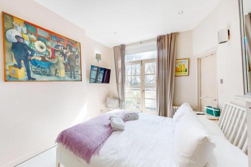 伦敦1 Bed Maisonette with Garden - 1 min to station Share Save的卧室配有白色的床和窗户。