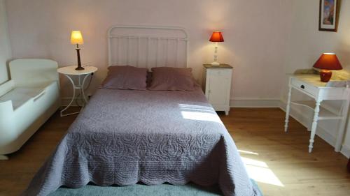 MartisserreMaison de 2 chambres avec jardin clos et wifi a Martisserre的一间卧室配有一张床、两张桌子和两盏灯。