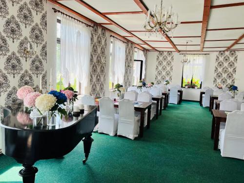 DoubiceHotel Jef a Krčma u Rytíře的宴会厅配有桌子、白色椅子和鲜花