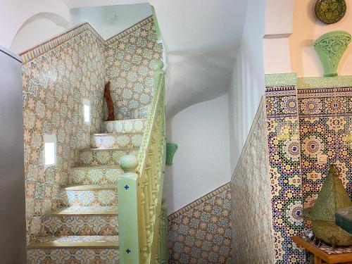 杰迪代Dar Statia 4 vue mer cité portugaise的一座马赛克墙的房屋内的楼梯