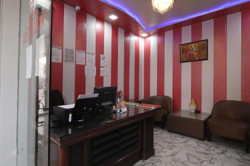 BijnaurHotel O Aastha Near Chaudhary Charan Singh International Airport的一间设有书桌和红色及白色条纹的等候室