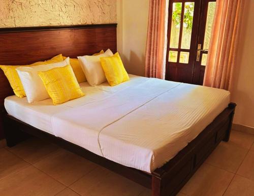 坦加拉AMOUR AT TURTLE BEACH的卧室内的一张带黄色枕头的大床
