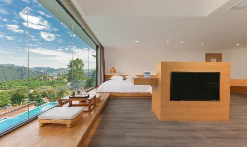 张家界Avatar Mountain Resort的一间卧室设有一张床和一个大窗户