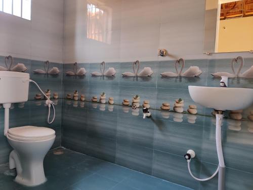 戈卡尔纳Niyam Beach Stay的浴室设有卫生间、水槽和一些粉红色的 ⁇ 豆