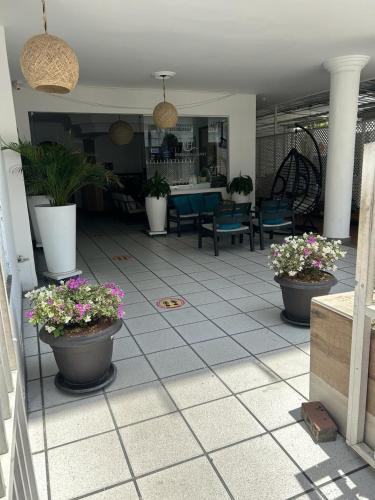 圣安德烈斯HOTEL HERNANDO HENRY的铺有瓷砖地板的庭院,种植了盆栽植物