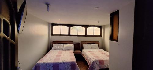 卡哈马卡La casa de Mary的带2扇窗户的小客房内的2张床