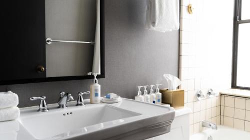 巴尔的摩Roomza Inner Harbor at Lord Baltimore的浴室设有白色水槽和镜子