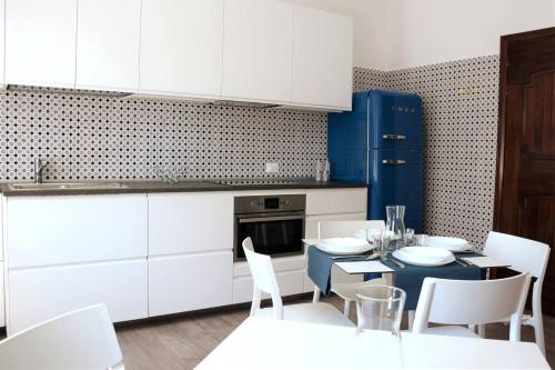 米拉dimora scaldaferro的厨房配有白色橱柜和桌椅