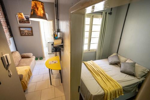 圣玛丽亚Apartamento no centro com estacionamento的小房间设有床和黄色椅子